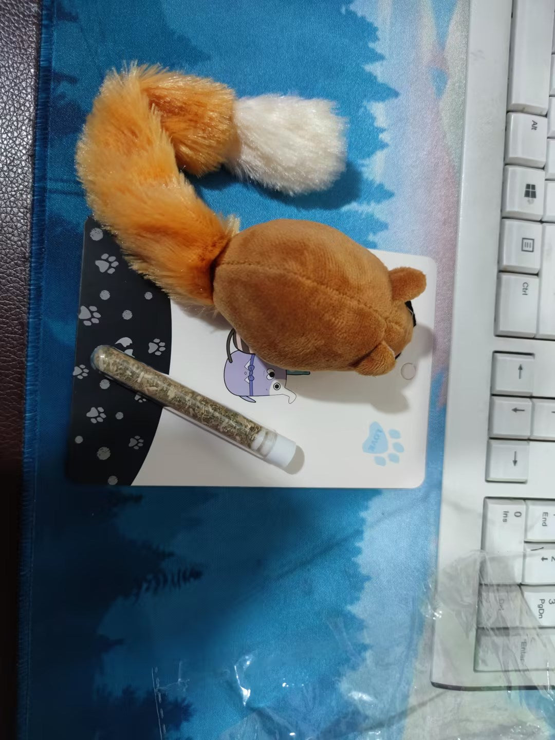 Shopi Vella interactive mouse cat toy with brown plush and bushy tail on blue surface